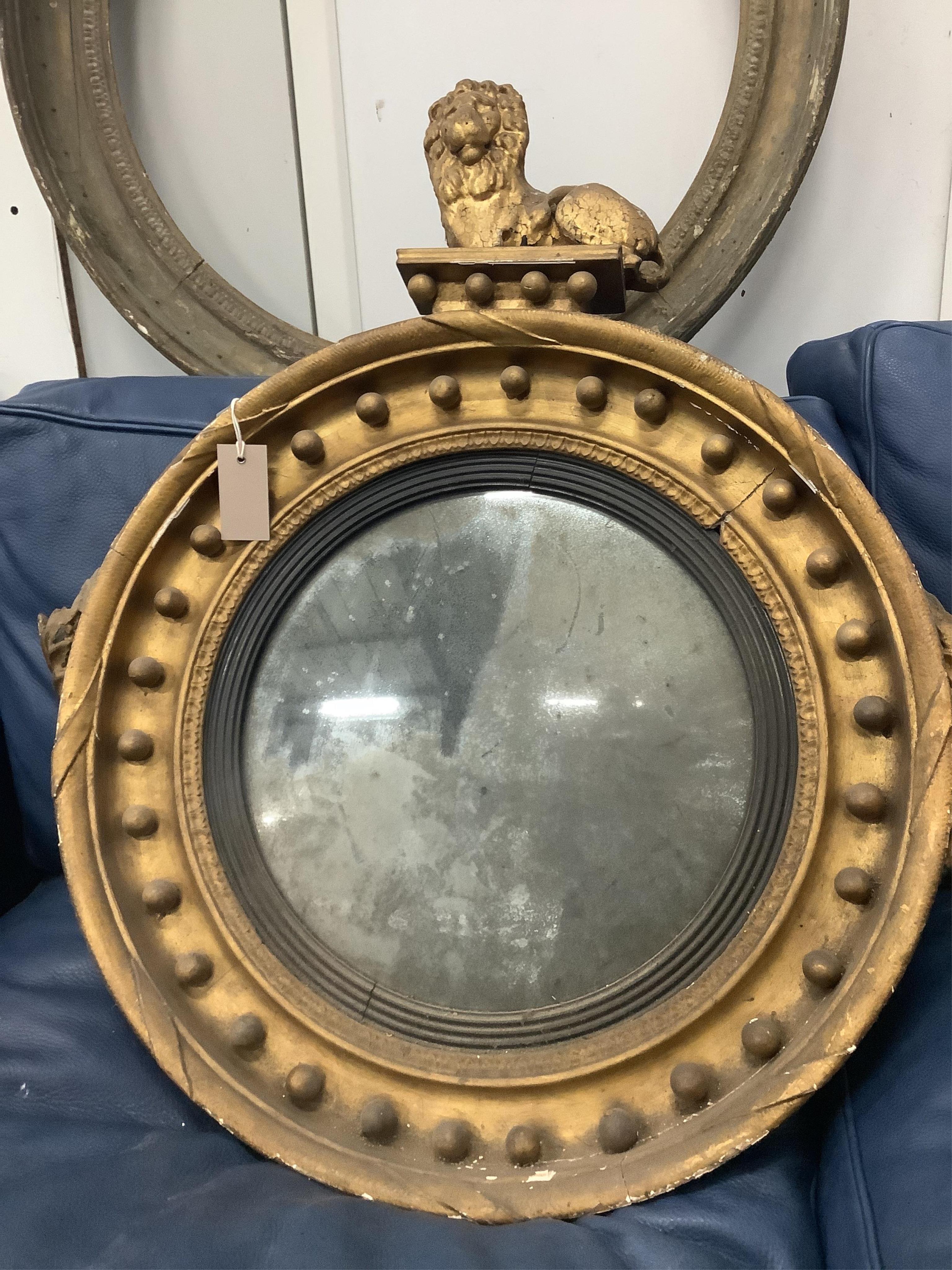 A Regency circular giltwood convex wall mirror with lion pediment, diameter 65cm a Regency convex mirror frame and Victorian girandole. Condition - poor